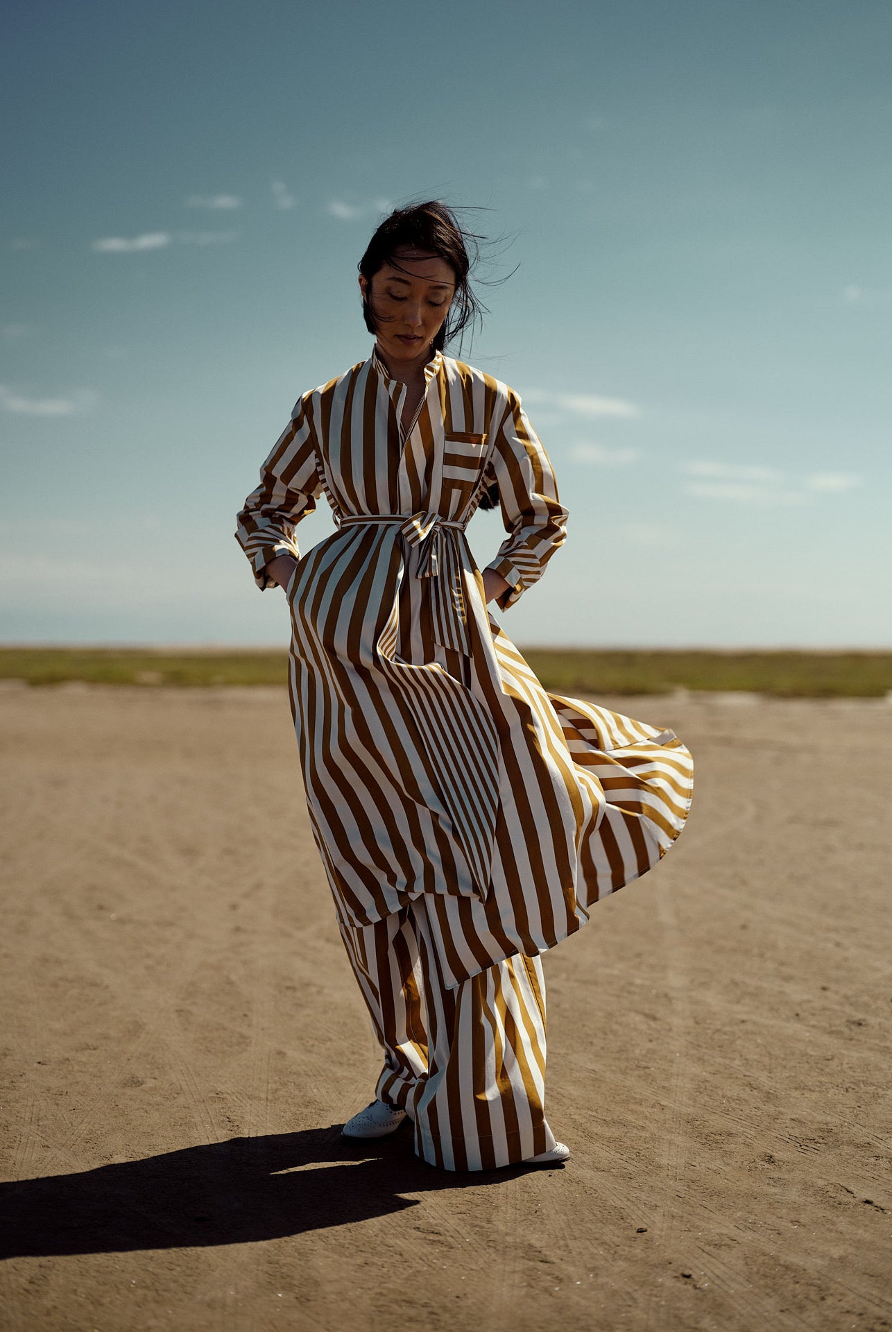 Model wearing Sacha dress in Tobacco with two-dimensional stripes.