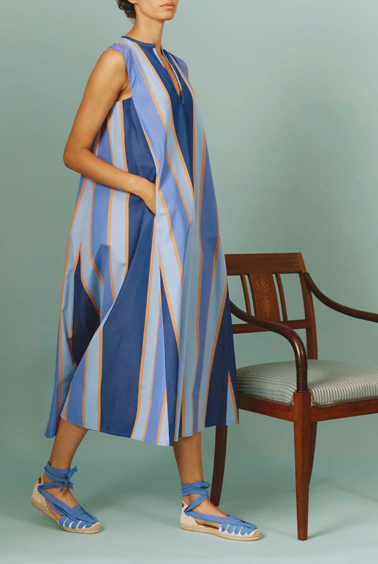 Side view of Apolonia Kaftan: Samarkand Stripes - Blue/Arancio | Spring/Summer 2024 by Thierry Colson - Hands in pockets
