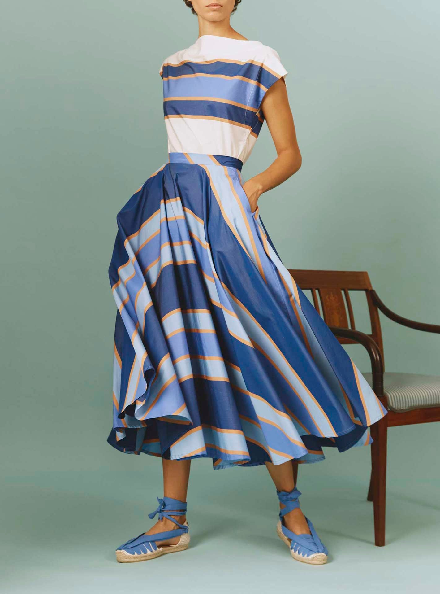 Front view of Audrey Skirt: Samarkand Stripes - Blue/Arancio by Thierry Colson | Spring/Summer 2024 - Hands in pockets