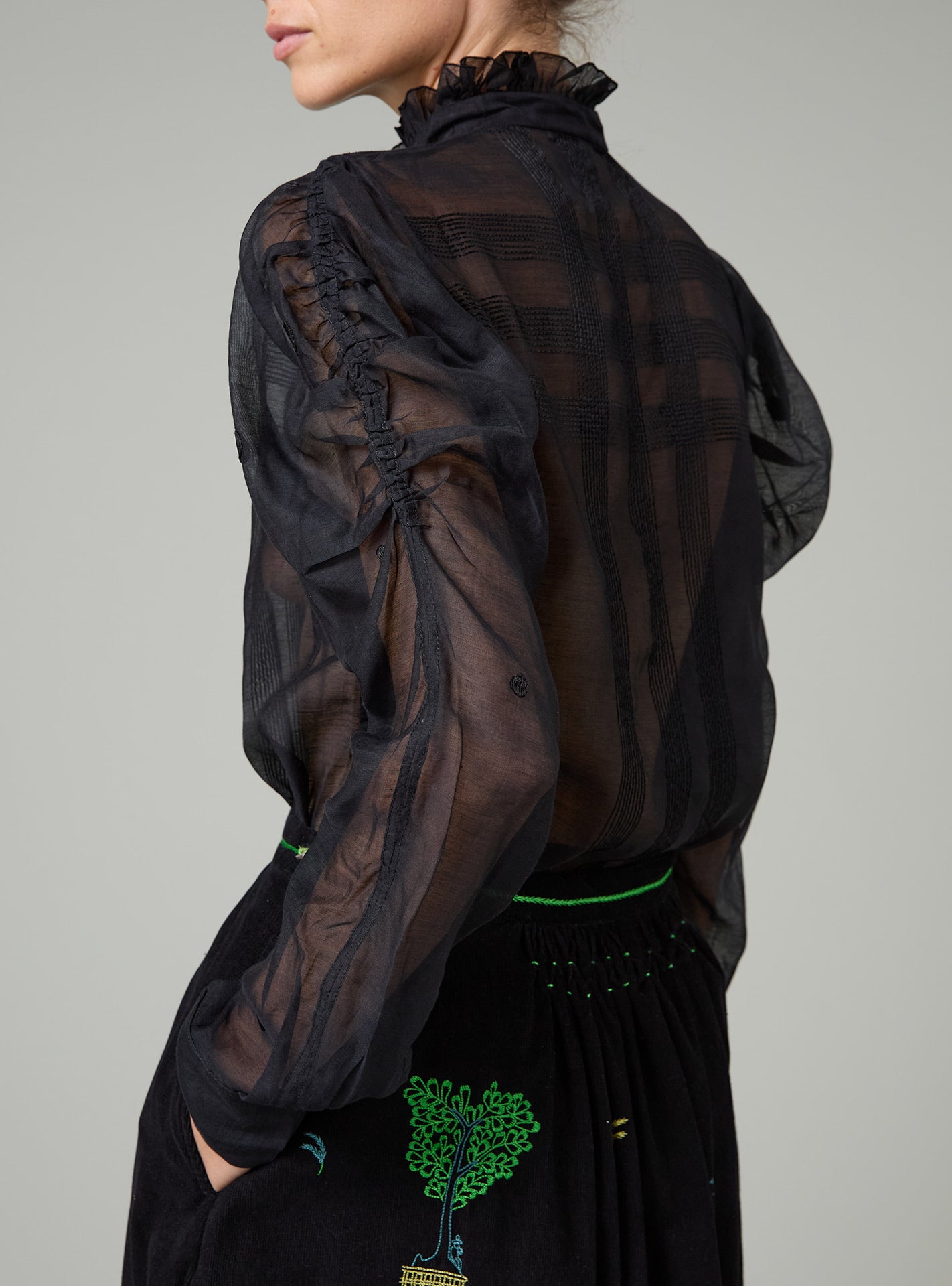 Black sheer blouse on a gray background