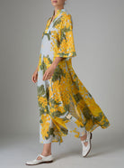 Side view of Rachel Kaftan in yellow and storm blue, featuring pagoda sleeves and high slit, inspired by mimosa gardens of the French Riviera. PS25 collection by Thierry Colson