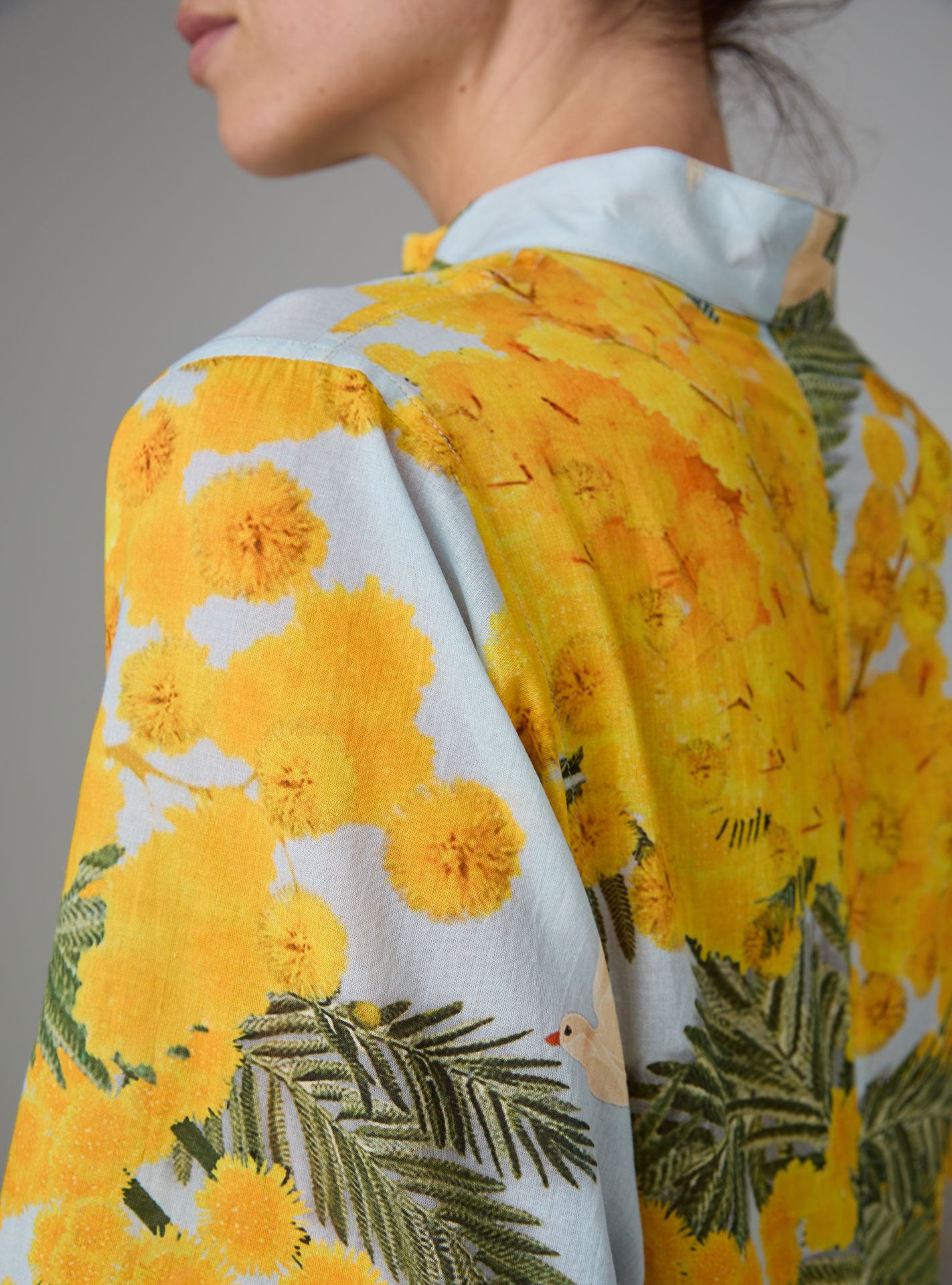 Detail view of Rachel Kaftan in yellow and storm blue, featuring pagoda sleeves and high slit, inspired by mimosa gardens of the French Riviera. PS25 collection by Thierry Colson