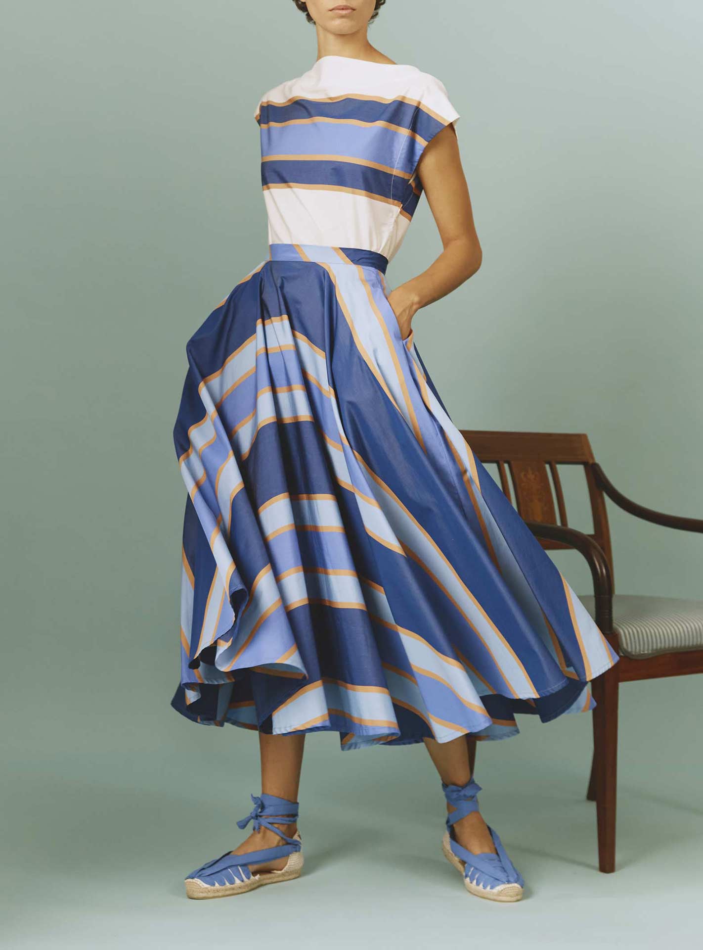 Front view of Audrey Skirt: Samarkand Stripes - Blue/Arancio by Thierry Colson | Spring/Summer 2024 - Hands in pockets