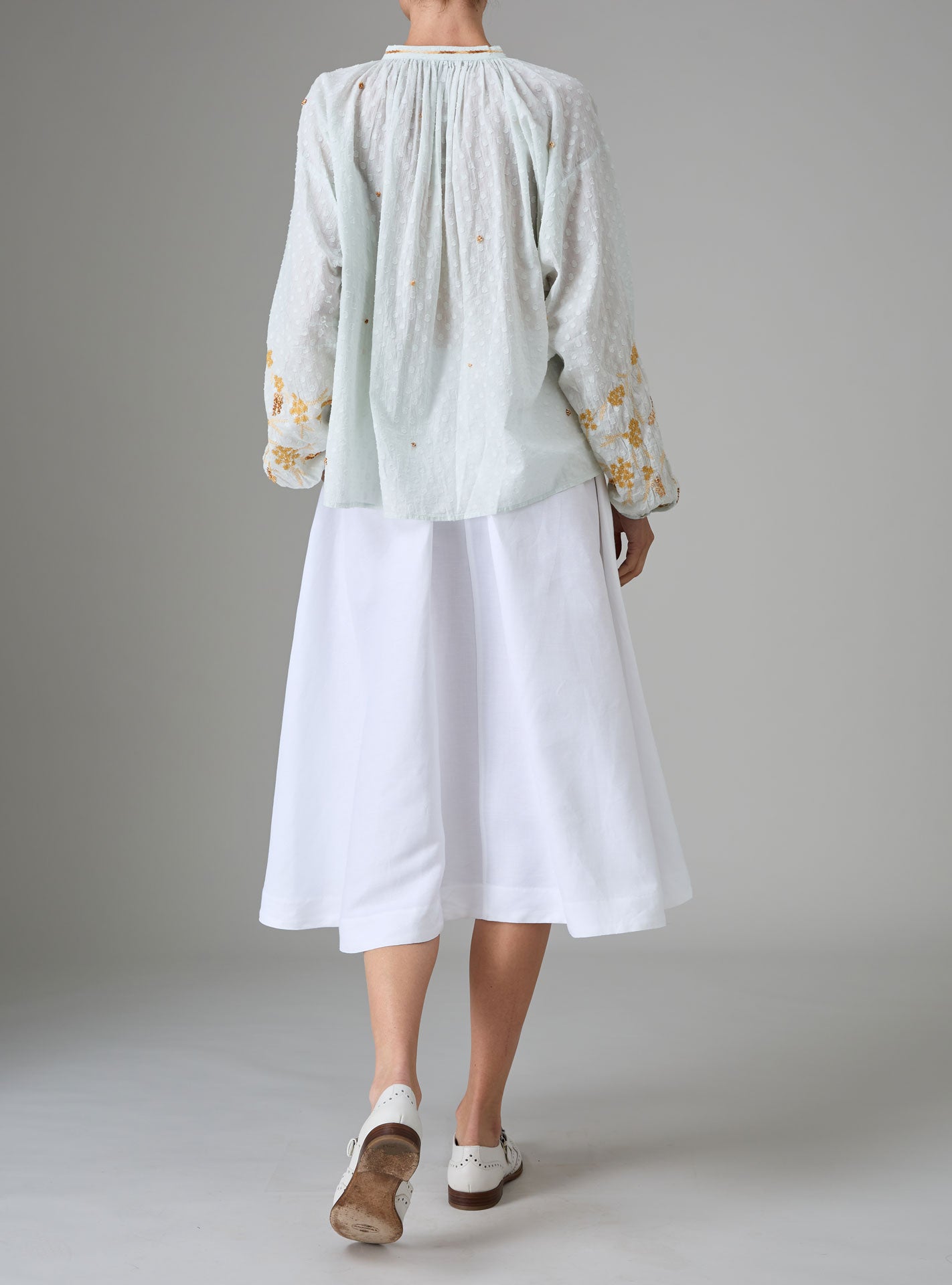 Back view of Guise Blouse in dobby cotton voile with Mediterranean-inspired hand embroidery by Thierry Colson