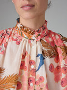 Detail view of SLAVA blouse with wide bell sleeves and collar band, crafted in pink and off-white digitally printed cotton voile for Pre-Spring 2025 by Thierry Colson