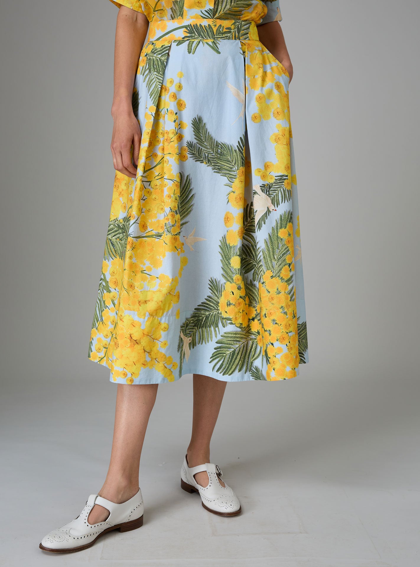 Front view of Wynona skirt in yellow and storm blue cotton poplin with Garden of Eden print, designed to create a slender silhouette for Pre-Spring 2025 by THierry Colson.