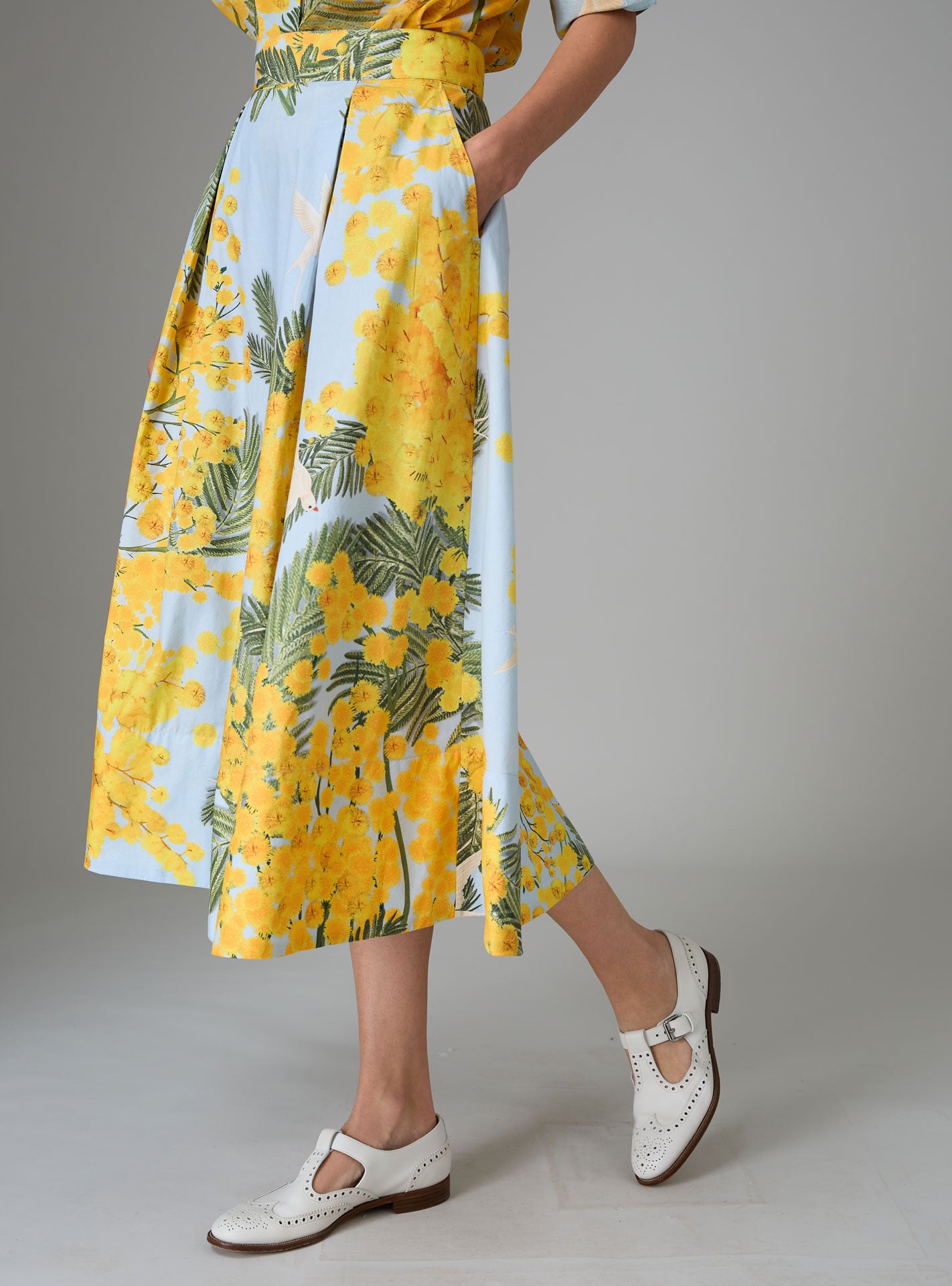 Side view of Wynona skirt in yellow and storm blue cotton poplin with Garden of Eden print, designed to create a slender silhouette for Pre-Spring 2025 by THierry Colson.