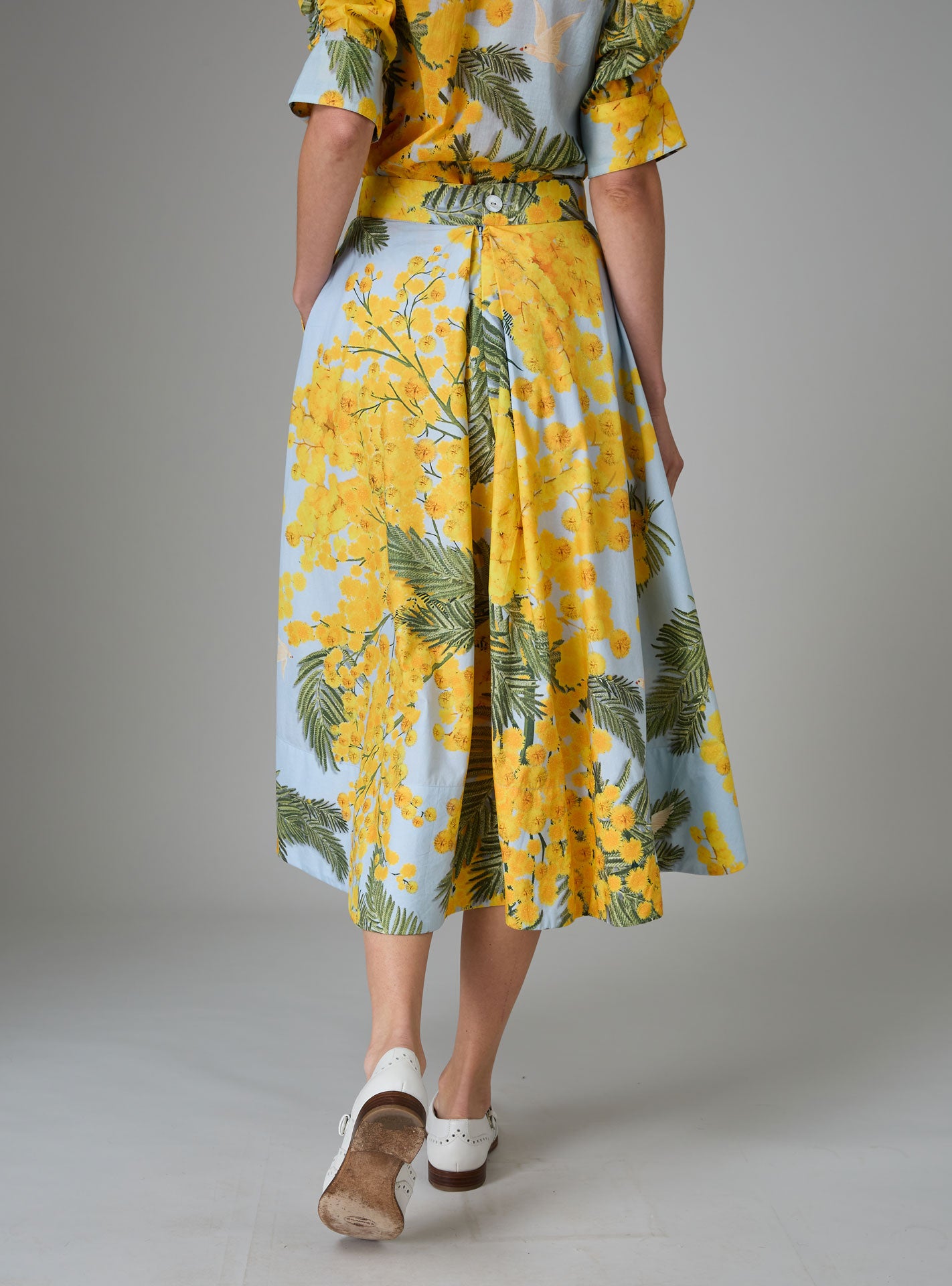 Back view of Wynona skirt in yellow and storm blue cotton poplin with Garden of Eden print, designed to create a slender silhouette for Pre-Spring 2025 by THierry Colson.