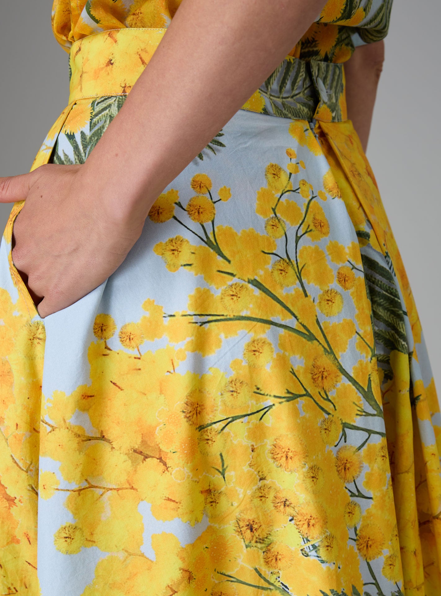 Detail of Wynona skirt in yellow and storm blue cotton poplin with Garden of Eden print, designed to create a slender silhouette for Pre-Spring 2025 by Thierry Colson.