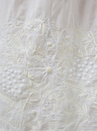 Close-up of white embroidered fabric with floral patterns