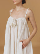 Close up of Zenobia Optical Pleats Off White long dress by Thierry Colson
