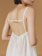 Close up back view of Zenobia Optical Pleats Off White long dress by Thierry Colson