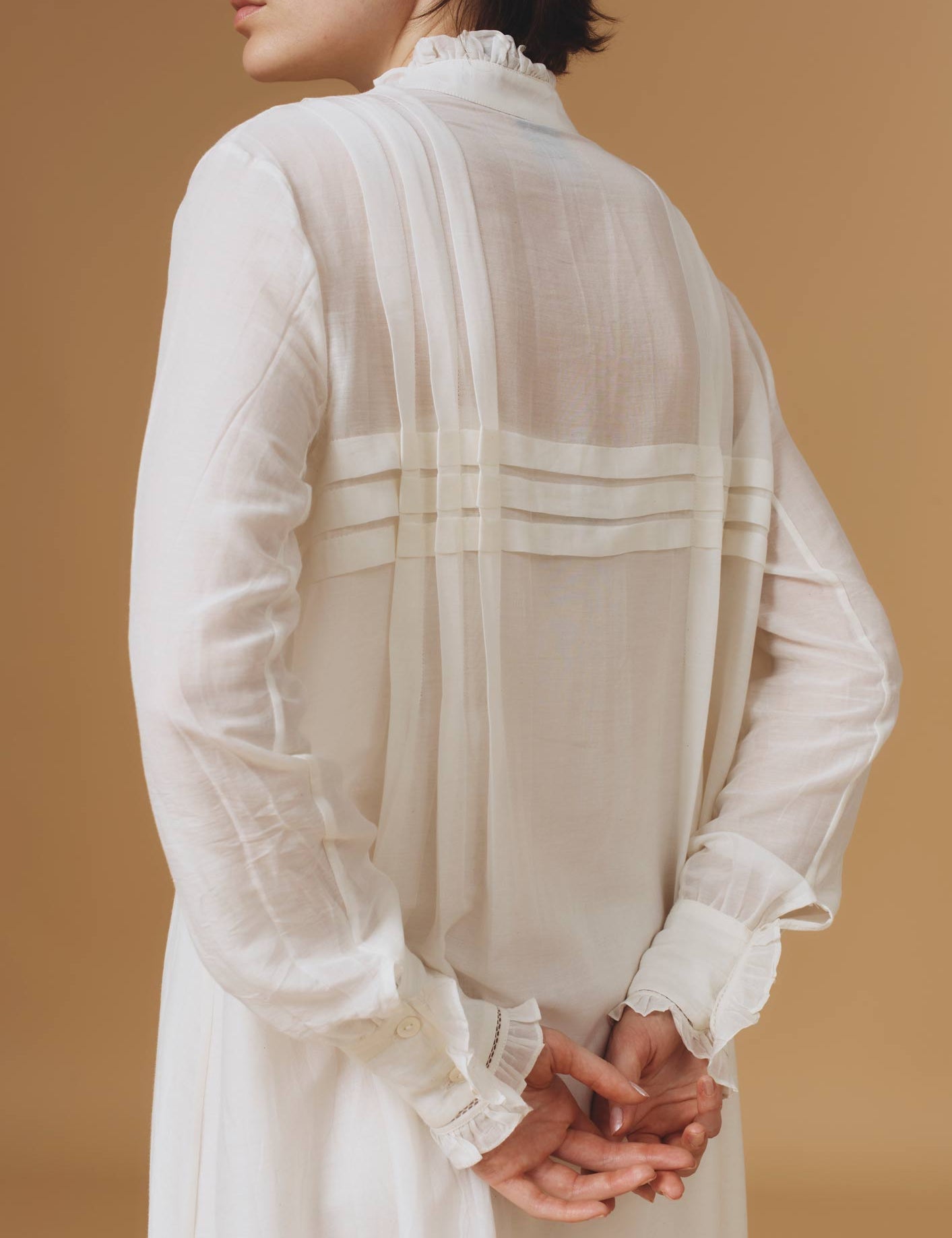 Close up back view of Zita Optical Pleats Off White dress by Thierry Colson