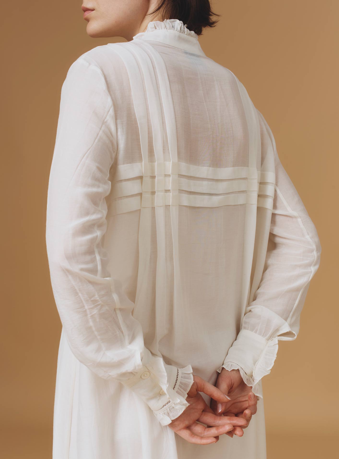Close up back view of Zita Optical Pleats Off White dress by Thierry Colson